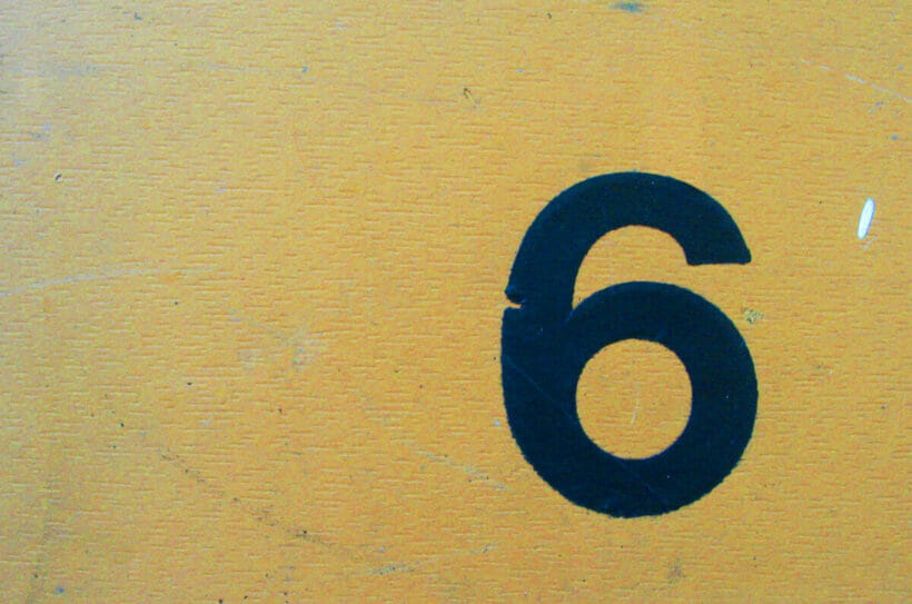 number six painted on a yellow wall